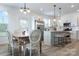 Modern kitchen and dining area with white cabinetry, stainless steel appliances, and eat-in island at 5112 Izzo Ln, Charlotte, NC 28214
