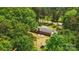 Aerial view featuring a brick home with a patio and outbuilding surrounded by trees at 6215 Simpson Rd, Charlotte, NC 28216
