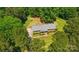 Aerial view showcases a brick home nestled among trees with a well-maintained yard at 6215 Simpson Rd, Charlotte, NC 28216