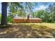 Expansive backyard view of red brick house and large trees at 6215 Simpson Rd, Charlotte, NC 28216