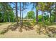 Charming single-story home with brick facade, complemented by a lush, mature tree-filled front lawn at 6215 Simpson Rd, Charlotte, NC 28216
