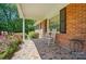Inviting front porch with mosaic tile flooring, white rocking chairs, and charming brick accents at 6215 Simpson Rd, Charlotte, NC 28216