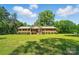 Traditional brick home with a manicured lawn and lush landscaping under a sunny, blue sky at 6215 Simpson Rd, Charlotte, NC 28216