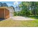 Driveway leading to a garage and backyard with mature trees along the property line at 6215 Simpson Rd, Charlotte, NC 28216