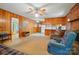 Wood-paneled living room with open layout, fireplace, ceiling fan, and a view into the kitchen at 6215 Simpson Rd, Charlotte, NC 28216