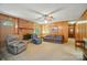 Wood-paneled living room featuring a brick fireplace, cozy seating, and a ceiling fan at 6215 Simpson Rd, Charlotte, NC 28216