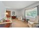 Bright living room featuring neutral carpeting and natural light from a large window with white frame at 6215 Simpson Rd, Charlotte, NC 28216