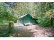 Outdoor shed with a green exterior surrounded by mature trees providing an abundance of shade at 6215 Simpson Rd, Charlotte, NC 28216
