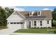 Charming home with white siding, dormer windows, and manicured front lawn and covered entryway at 7017 Treetop Ct, York, SC 29745