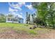 The backyard shows the house and sunroom, as well as a fire pit and mature trees at 7218 Jacobs Fork Ln, Charlotte, NC 28273