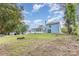 Backyard view showcasing the house and sunroom with a spacious yard, fire pit, and trees at 7218 Jacobs Fork Ln, Charlotte, NC 28273
