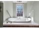 Relaxing bathroom showcasing a soaking tub with gold fixtures under a bright window at 7648 Forest Oak Dr, Denver, NC 28037