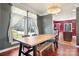 Bright dining room featuring hardwood floors, a large table, and scenic outdoor views through expansive windows at 7648 Forest Oak Dr, Denver, NC 28037