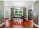 Bright dining area features hardwood floors, a rustic table, and large windows offering a view of the backyard at 7648 Forest Oak Dr, Denver, NC 28037