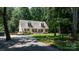 View of a two-story home with a welcoming front porch, hardwood deck, mature trees and long driveway at 7648 Forest Oak Dr, Denver, NC 28037