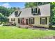 Charming two-story home with dormer windows, front porch, American flag and green lawn at 7648 Forest Oak Dr, Denver, NC 28037