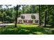 Inviting home with dormer windows, front porch, wood deck and surrounded by mature trees and lush lawn at 7648 Forest Oak Dr, Denver, NC 28037