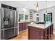 Bright kitchen features stainless steel appliances, granite countertops, and custom plum-colored cabinets at 7648 Forest Oak Dr, Denver, NC 28037