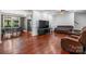 Open floor plan featuring a dining area, living room with hardwood floors, a large TV, and comfortable seating at 7648 Forest Oak Dr, Denver, NC 28037