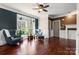 Bright living room with hardwood floors, two armchairs, a fireplace, and large windows showcasing outdoor views at 7648 Forest Oak Dr, Denver, NC 28037