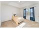 Bedroom featuring a comfortable bed with tray ceiling and window with curtains at 8414 Oak Ne Dr, Charlotte, NC 28269