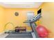 Bright yellow exercise room featuring a treadmill, weights, and fitness ball at 8414 Oak Ne Dr, Charlotte, NC 28269