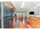 Open kitchen view with wood floors, stainless steel appliances, wood cabinets, and a sunlit breakfast nook at 8414 Oak Ne Dr, Charlotte, NC 28269