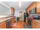 Well-lit kitchen featuring wood-look floors, stainless steel appliances, ample counter space, and wooden cabinets at 8414 Oak Ne Dr, Charlotte, NC 28269
