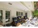 Covered back porch with blue cushioned patio furniture and view of mature trees at 981 Sherwood Cir, Lancaster, SC 29720
