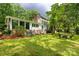 Backyard with green grass, shade trees, and a white house featuring a wall of windows at 981 Sherwood Cir, Lancaster, SC 29720