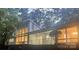 A modern-style home with large windows, an outdoor seating area, and ambient interior lighting at 981 Sherwood Cir, Lancaster, SC 29720