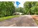 Exterior shot of a charming single-story home with a long driveway and lush green surroundings at 981 Sherwood Cir, Lancaster, SC 29720