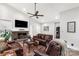 Cozy living room with a brick fireplace, leather furniture, and a ceiling fan at 981 Sherwood Cir, Lancaster, SC 29720