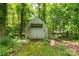 Exterior view of the storage shed surrounded by a lush, wooded environment at 981 Sherwood Cir, Lancaster, SC 29720