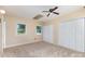 Bedroom with neutral carpet and walls, a ceiling fan, two windows, a skylight, and a double closet at 103 Sadler Rd, Mount Holly, NC 28120