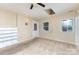 Bedroom with neutral carpet and walls, a ceiling fan, a skylight, two windows, and a door at 103 Sadler Rd, Mount Holly, NC 28120