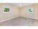 This bedroom has two windows providing natural light and tan carpeting at 103 Sadler Rd, Mount Holly, NC 28120