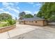 Brick home with a large driveway, well-maintained landscaping, and a detached garage on a sunny day at 103 Sadler Rd, Mount Holly, NC 28120