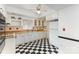 Bright kitchen with classic black-and-white tile flooring, ample cabinet space and a view to the backyard at 103 Sadler Rd, Mount Holly, NC 28120