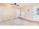Living room featuring neutral carpet and walls, a ceiling fan, white door, and a bookshelf at 103 Sadler Rd, Mount Holly, NC 28120