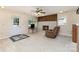 Cozy living area featuring a brick fireplace, a comfortable recliner, and plenty of natural light at 103 Sadler Rd, Mount Holly, NC 28120
