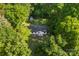 Aerial view of a home nestled in a lush, green, wooded area with a storage shed in the backyard at 1055 Cedar Hill Dr, Rockwell, NC 28138