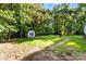 Backyard featuring a storage shed, partially shaded lawn, and mature trees at 1055 Cedar Hill Dr, Rockwell, NC 28138