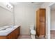 Bathroom with double sinks, wood cabinets, a toilet, and new floors at 1055 Cedar Hill Dr, Rockwell, NC 28138