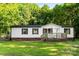 Charming home featuring white siding, black shutters, a wooden deck, and a well-maintained lawn at 1055 Cedar Hill Dr, Rockwell, NC 28138