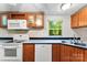 Kitchen area features white appliances and wooden cabinets with modern flooring at 1055 Cedar Hill Dr, Rockwell, NC 28138
