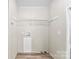 Functional laundry room with overhead shelving and modern vinyl flooring at 1055 Cedar Hill Dr, Rockwell, NC 28138