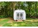 Backyard shed with double doors in a wooded setting with a green lawn at 1055 Cedar Hill Dr, Rockwell, NC 28138