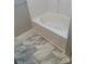 A white tub and marbled tile floor at 11622 Lioness St, Charlotte, NC 28273