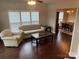 Cozy living room featuring hardwood floors, neutral furniture, and view of the dining area at 11622 Lioness St, Charlotte, NC 28273
